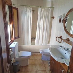 a bathroom with a toilet and a sink and a mirror at Casa Verilia in Olombrada