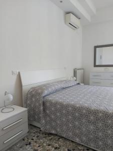 1 dormitorio con cama, tocador y espejo en CASA VACANZE VITTORIA COLONNA en Isquia
