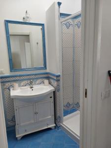 uma casa de banho com um lavatório, um espelho e um chuveiro em CASA VACANZE VITTORIA COLONNA em Ischia