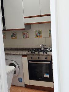 a kitchen with a stove and a washing machine at CASA VACANZE VITTORIA COLONNA in Ischia