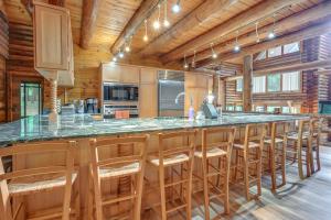 a kitchen with a large island with bar stools at Magical Metamora Cottage with Fire Pit, Pond, Deck! in Metamora