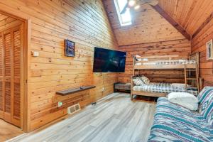 a log cabin with a tv and two bunk beds at Magical Metamora Cottage with Fire Pit, Pond, Deck! in Metamora