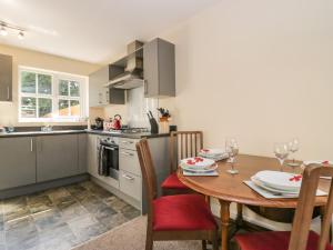 a kitchen with a wooden table and a table and chairs at Rolo's Retreat in Grange Over Sands