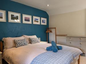 1 dormitorio con 1 cama con pared azul en The Old Dairy en Bridport