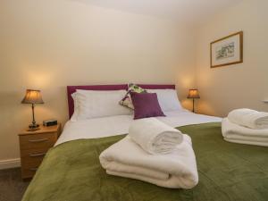 a bedroom with a bed with towels on it at Rolo's Retreat in Grange Over Sands