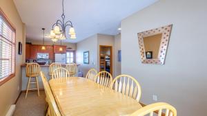 a dining room and kitchen with a wooden table and chairs at Trails Edge #03 By Bear Country in Sun Peaks