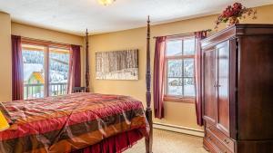 a bedroom with a bed and a large window at Trails Edge #03 By Bear Country in Sun Peaks