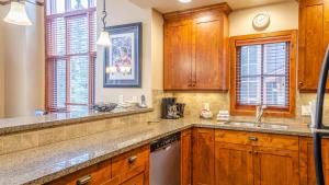 a kitchen with wooden cabinets and a sink at Woodhaven #32 By Bear Country in Sun Peaks