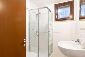 a bathroom with a glass shower stall and a sink at Sa Perda 20 - FREE WIFI - 500mt from the beach in Costa Rei