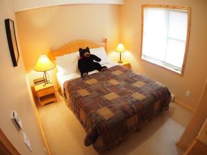 a teddy bear sitting on a bed in a bedroom at Crystal Forest #07 By Bear Country in Sun Peaks