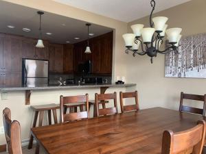 a kitchen with a wooden table and a dining room at Woodhaven #19 by Bear Country in Sun Peaks