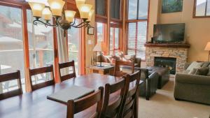 a dining room with a table and a fireplace at Woodhaven #19 by Bear Country in Sun Peaks