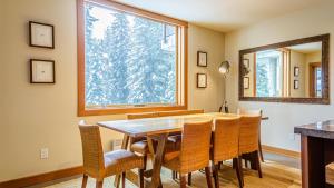 comedor con mesa y sillas y ventana grande en Kookaburra Lodge #303 By Bear Country, en Sun Peaks