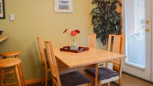 a wooden table with chairs and a vase with flowers on it at Crystal Forest #23 By Bear Country in Sun Peaks