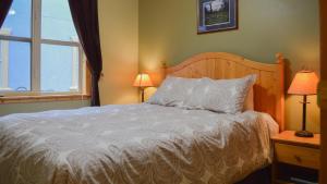 a bedroom with a bed and two lamps and a window at Crystal Forest #23 By Bear Country in Sun Peaks