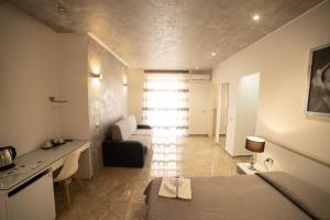 a room with a bed and a couch and a desk at Tropea Luxury & Charm in Tropea