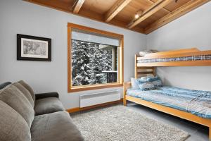 een slaapkamer met een stapelbed en een bank bij Kookaburra Lodge #203 By Bear Country in Sun Peaks