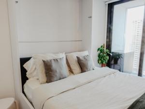 a bedroom with a bed with white sheets and pillows at NEW Luxury Sunrise Oceanview Aparthotel in Gibraltar in Gibraltar