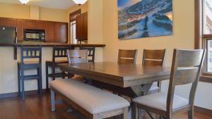 a dining room with a wooden table and chairs at Stones Throw #24 in Sun Peaks