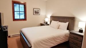 um quarto com uma cama branca e uma janela em Trappers Landing #34 by Bear Country em Sun Peaks