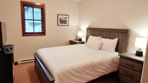 a bedroom with a white bed and a window at Trappers Landing #34 in Sun Peaks
