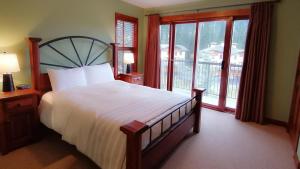 a bedroom with a large bed with a large window at Trappers Landing #34 in Sun Peaks