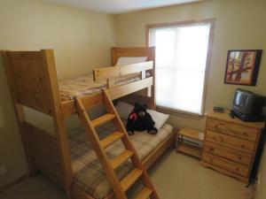 a teddy bear sitting on a bunk bed in a bedroom at Crystal Forest #63 By Bear Country in Sun Peaks