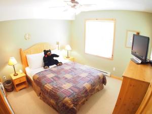 um urso de peluche sentado numa cama num quarto em Crystal Forest #04 By Bear Country em Sun Peaks