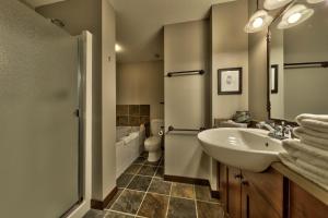 Un baño con lavabo, inodoro y espejo. en Stones Throw #56 By Bear Country, en Sun Peaks