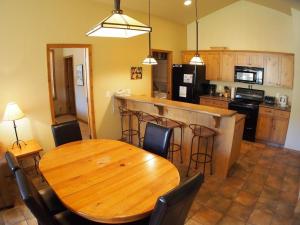 a kitchen with a wooden table and a table and chairs at Crystal Forest #72 By Bear Country in Sun Peaks