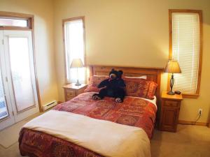 um urso de peluche sentado numa cama num quarto em Crystal Forest #72 By Bear Country em Sun Peaks