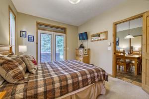 a bedroom with a bed and a table and a desk at Crystal Forest #65 By Bear Country in Sun Peaks
