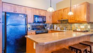 a kitchen with a blue refrigerator and wooden cabinets at Settlers Crossing #61 by Bear Country in Sun Peaks