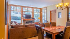 a living room with a couch and a tv and a table at Settlers Crossing #61 by Bear Country in Sun Peaks