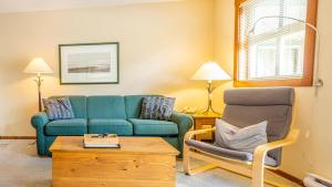 sala de estar con sofá azul y silla en Fireside Lodge #223 By Bear Country, en Sun Peaks