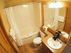 a bathroom with a sink and a toilet and a tub at Crystal Forest #62 By Bear Country in Sun Peaks