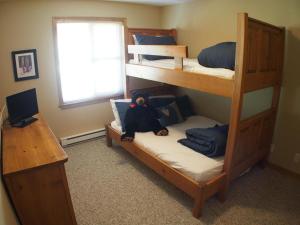 a bedroom with bunk beds with a teddy bear sitting on the bottom bunk at Crystal Forest #62 By Bear Country in Sun Peaks