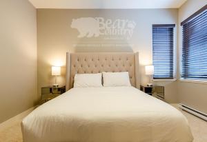 a bedroom with a large white bed with two lamps at Echo Landing #12 by Bear Country in Sun Peaks