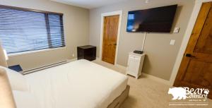 a bedroom with a bed and a flat screen tv at Echo Landing #12 by Bear Country in Sun Peaks