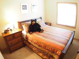 a teddy bear sitting on a bed in a bedroom at Crystal Forest #60 By Bear Country in Sun Peaks