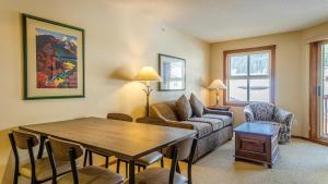 a living room with a couch and a table at Fireside Lodge #413 By Bear Country in Sun Peaks
