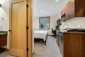 a room with a kitchen and a bedroom with a bed at Kookaburra Lodge #302 By Bear Country in Sun Peaks