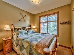 ein Schlafzimmer mit einem großen Bett und einem Fenster in der Unterkunft Settlers Crossing #70 by Bear Country in Sun Peaks