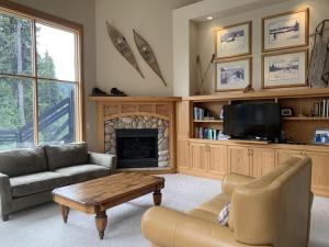 a living room with a couch and a fireplace at On the Run Chalet by Bear Country in Sun Peaks