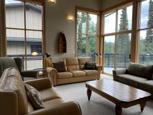 a living room with couches and a coffee table at On the Run Chalet by Bear Country in Sun Peaks