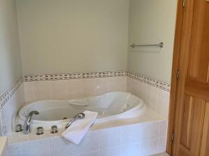 a bath tub with a towel in a bathroom at On the Run Chalet by Bear Country in Sun Peaks