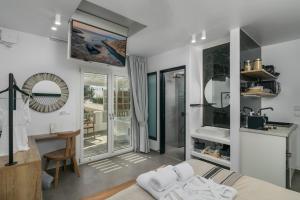 a room with a bed and a desk and a mirror at Orama Suites Milos in Adamantas