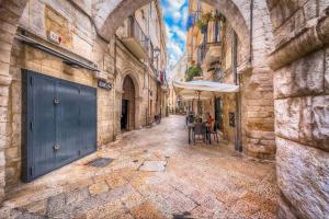 un callejón con mesas y una sombrilla en una calle en SUMMER PARADISE en Bari