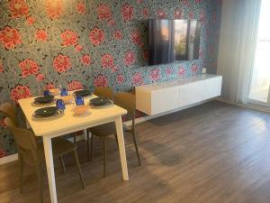 a dining room with a table with chairs and a television at SUMMER PARADISE in Bari