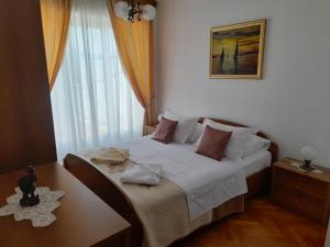 Un dormitorio con una cama y una ventana. en VILLA Apartments Mate Cebalo, en Lumbarda